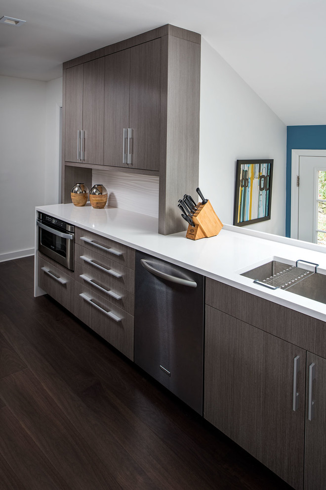 Inspiration for a large modern l-shaped eat-in kitchen in New York with an undermount sink, flat-panel cabinets, grey cabinets, quartzite benchtops, white splashback, porcelain splashback, stainless steel appliances, dark hardwood floors and with island.