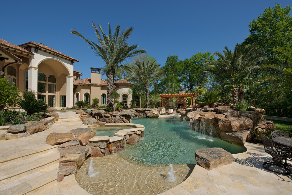 Design ideas for a mediterranean custom-shaped natural pool in Houston with a water feature.