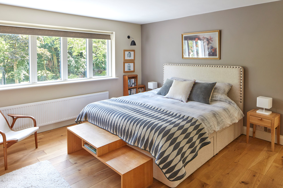 Inspiration for a mid-sized transitional bedroom in Berkshire with beige walls, medium hardwood floors and brown floor.