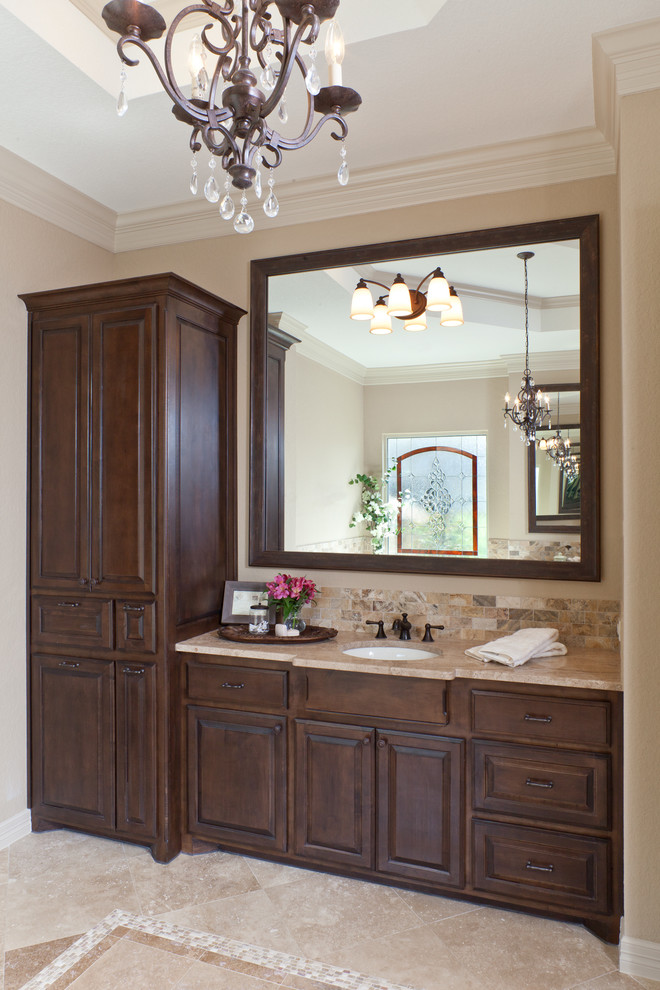 Inspiration for a mid-sized traditional master bathroom in Houston with an undermount sink, raised-panel cabinets, dark wood cabinets, granite benchtops, beige tile, stone tile, travertine floors and beige walls.