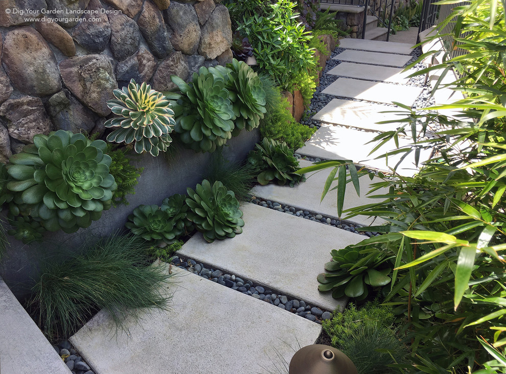 Photo of a small contemporary front yard partial sun xeriscape for fall in San Francisco with natural stone pavers.