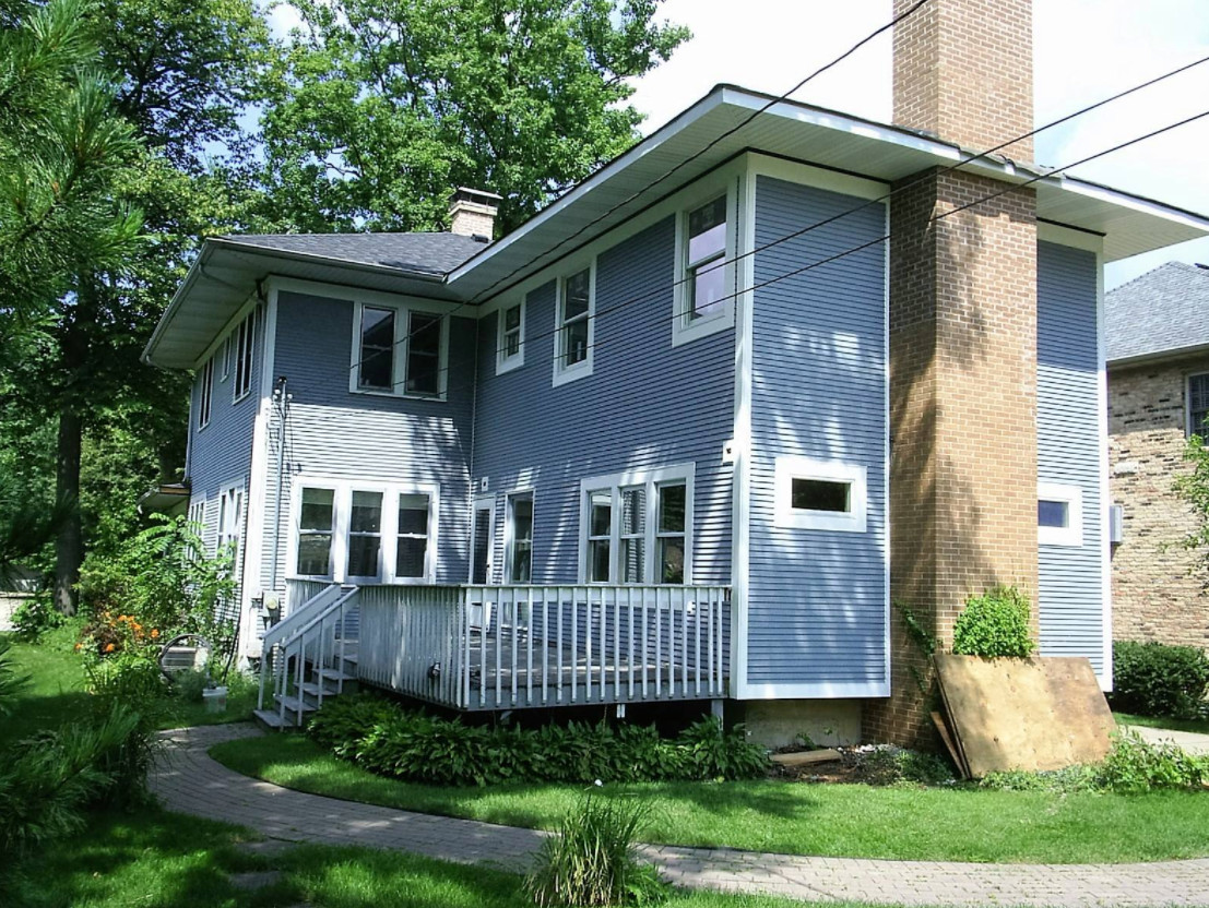 Inspiration for a mid-sized timeless blue two-story vinyl house exterior remodel in Chicago with a hip roof and a shingle roof