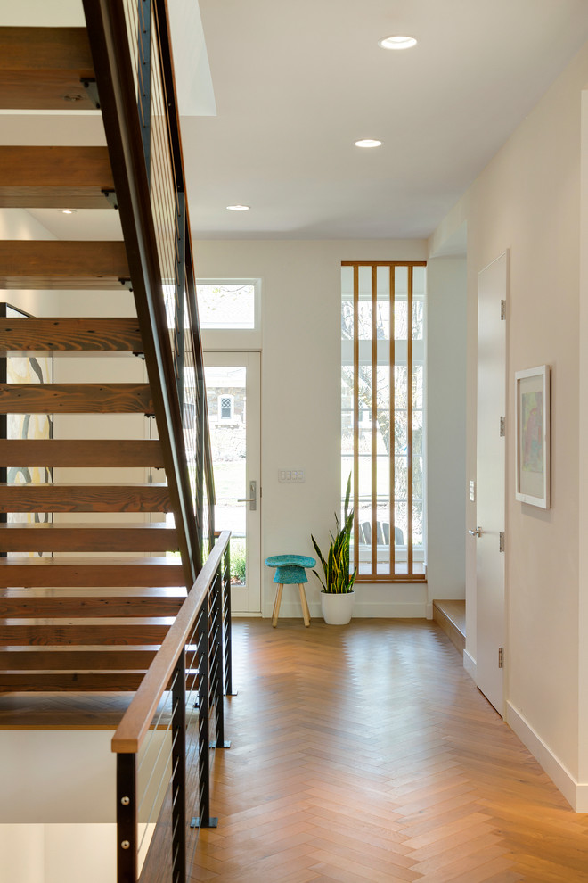 Inspiration for a mid-century modern light wood floor entryway remodel in Minneapolis with white walls and a white front door
