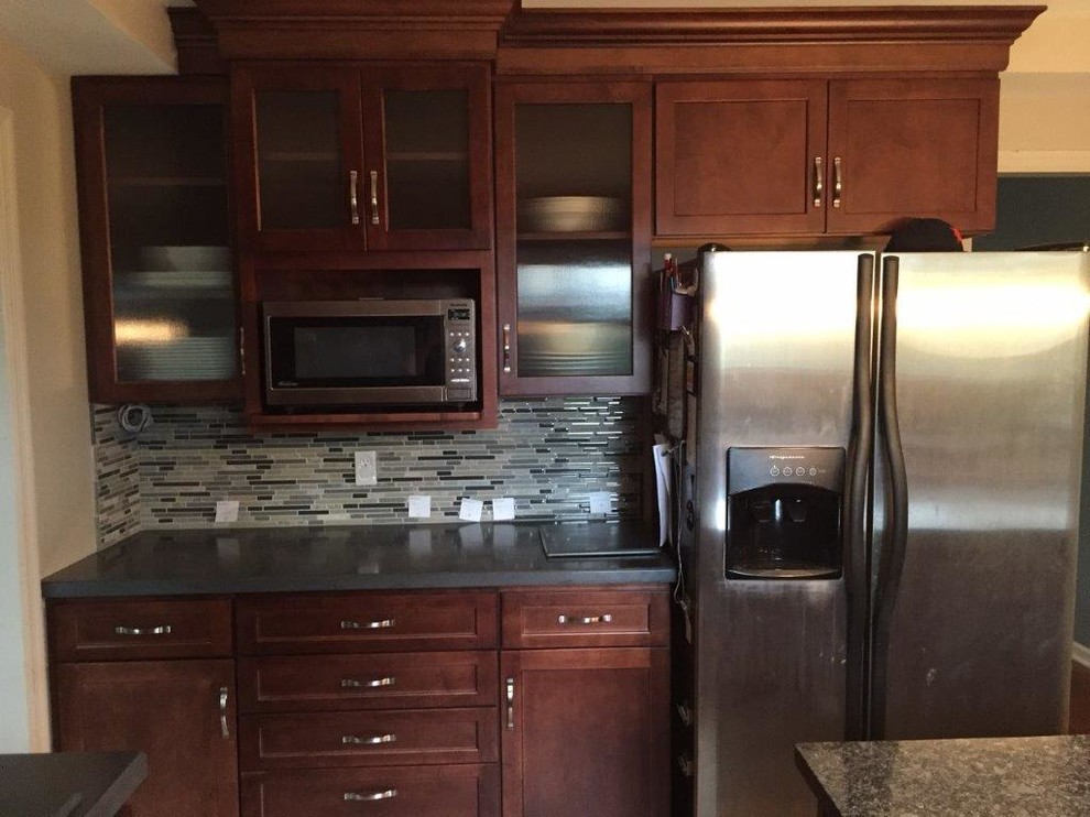 Example of a mid-sized transitional l-shaped porcelain tile eat-in kitchen design in Cincinnati with an undermount sink, shaker cabinets, granite countertops, multicolored backsplash, glass tile backsplash, stainless steel appliances, an island and dark wood cabinets