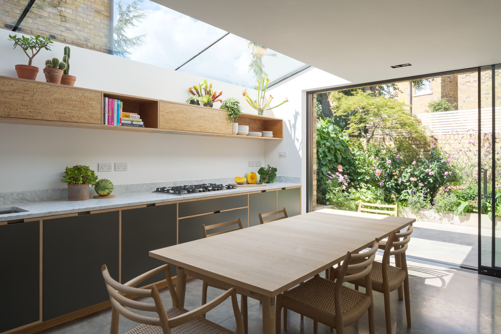 Inspiration for a modern kitchen in London with an undermount sink, flat-panel cabinets, marble benchtops, panelled appliances, concrete floors, no island and grey floor.