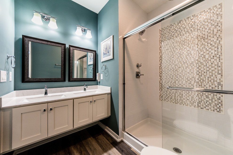 Inspiration for a mid-sized transitional 3/4 bathroom in Other with shaker cabinets, white cabinets, an alcove shower, a two-piece toilet, beige tile, mosaic tile, blue walls, dark hardwood floors, an undermount sink, engineered quartz benchtops, brown floor and a sliding shower screen.