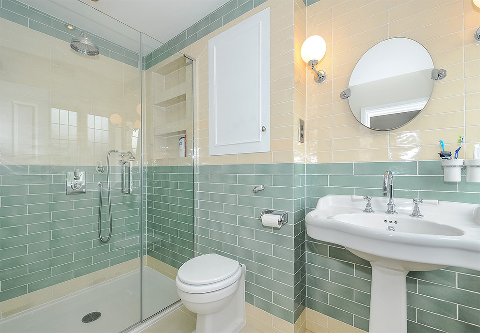This is an example of a small contemporary master bathroom in London with recessed-panel cabinets, a double shower, multi-coloured tile, ceramic floors, a pedestal sink, porcelain tile, a wall-mount toilet, multi-coloured walls and a hinged shower door.