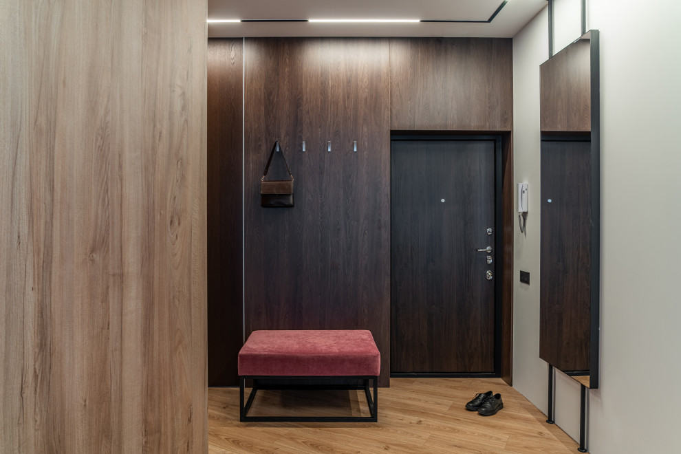 Свежая идея для дизайна: входная дверь среднего размера в скандинавском стиле с коричневыми стенами, полом из ламината, одностворчатой входной дверью, входной дверью из темного дерева, бежевым полом и деревянными стенами - отличное фото интерьера