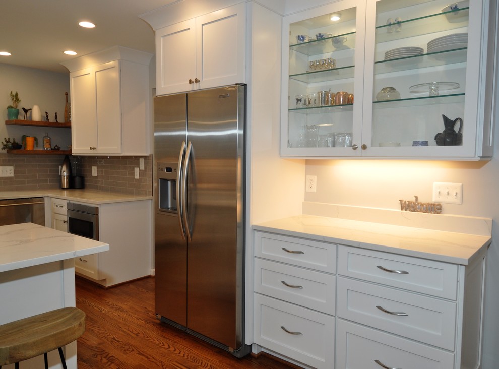 This is an example of a mid-sized transitional u-shaped eat-in kitchen in DC Metro with white cabinets and stainless steel appliances.