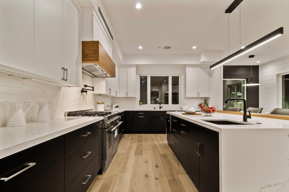 Large country l-shaped eat-in kitchen in Los Angeles with an undermount sink, marble benchtops, beige splashback, stainless steel appliances, with island and multi-coloured benchtop.