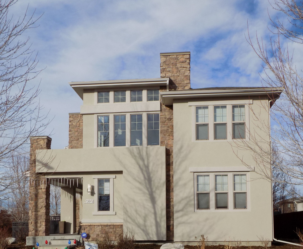 Foto della villa grande beige contemporanea a due piani con rivestimento in stucco, copertura a scandole e tetto marrone