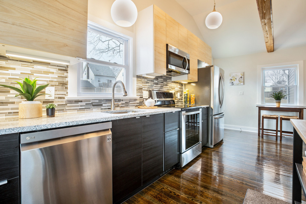 Inspiration for a small transitional galley dark wood floor, brown floor and exposed beam eat-in kitchen remodel in Wilmington with an undermount sink, flat-panel cabinets, light wood cabinets, granite countertops, metallic backsplash, mosaic tile backsplash, stainless steel appliances, an island and multicolored countertops