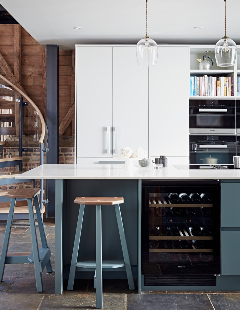 Photo of a large contemporary kitchen in Surrey with flat-panel cabinets, grey cabinets, quartz worktops and an island.