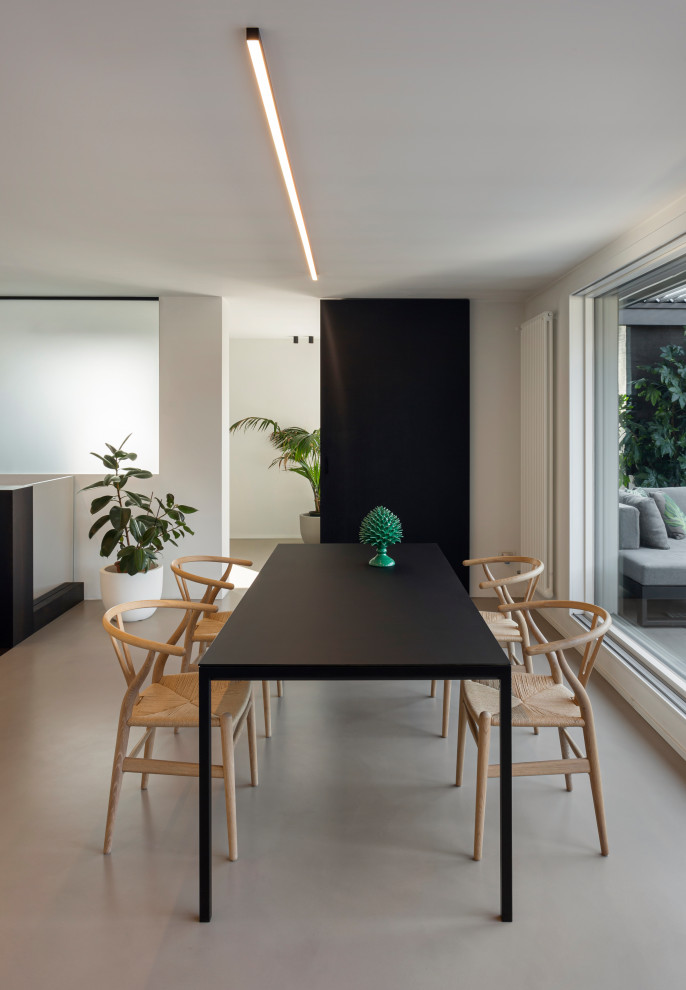 This is an example of a large contemporary open plan dining room in Milan with white walls, concrete flooring, a ribbon fireplace, a metal fireplace surround, brown floors and a drop ceiling.