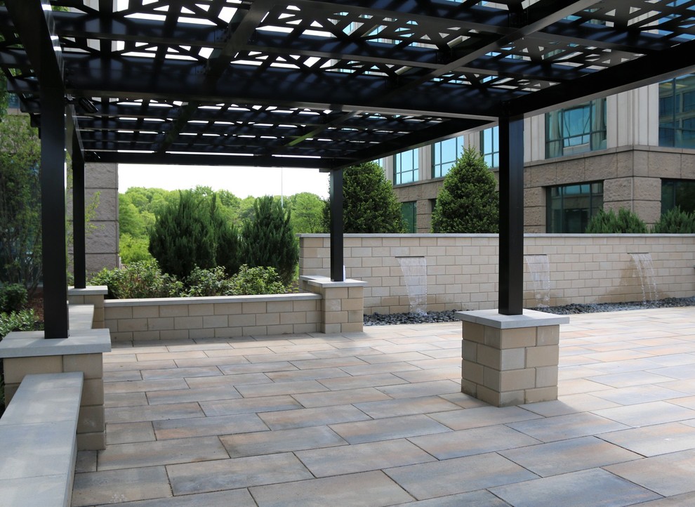 Mid-sized traditional courtyard patio in Chicago with a water feature and concrete pavers.