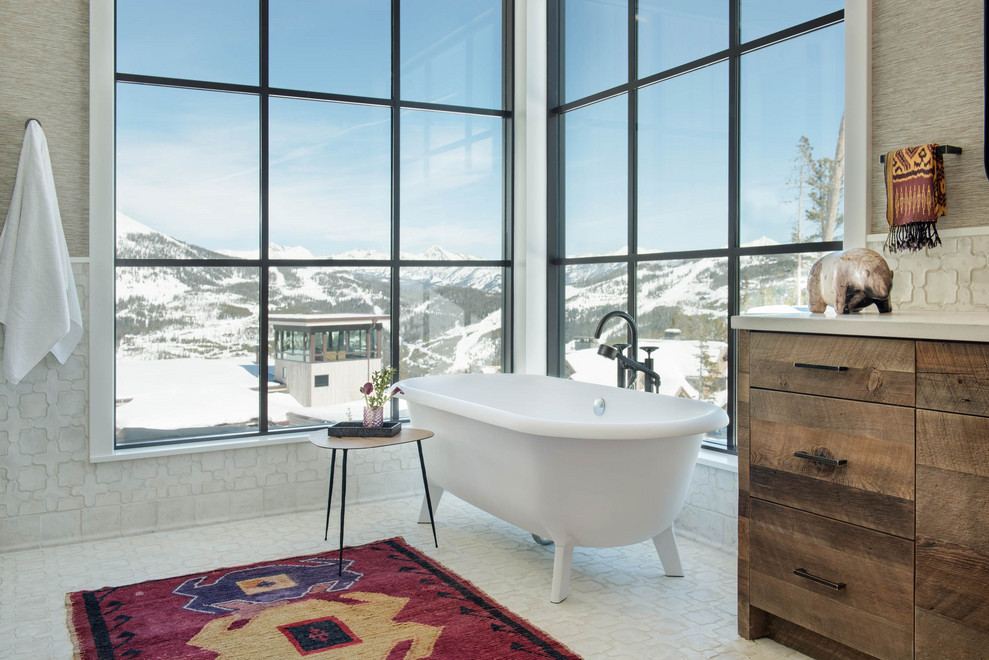Example of a mountain style master white tile white floor claw-foot bathtub design with flat-panel cabinets, distressed cabinets, beige walls and beige countertops