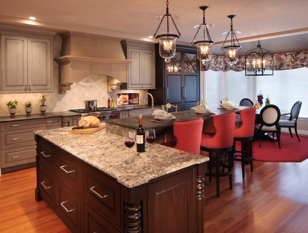 This is an example of a large traditional eat-in kitchen in Denver with a double-bowl sink, granite benchtops, stainless steel appliances, medium hardwood floors and with island.