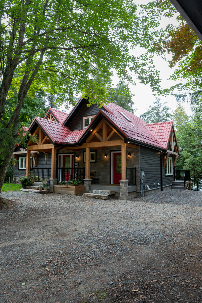 На фото: трехэтажный, черный частный загородный дом среднего размера в стиле рустика с комбинированной облицовкой, двускатной крышей, металлической крышей, красной крышей и отделкой планкеном с