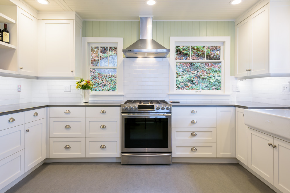 Inspiration for a mid-sized country kitchen in Seattle with a farmhouse sink, shaker cabinets, white cabinets, white splashback, subway tile splashback, stainless steel appliances and linoleum floors.