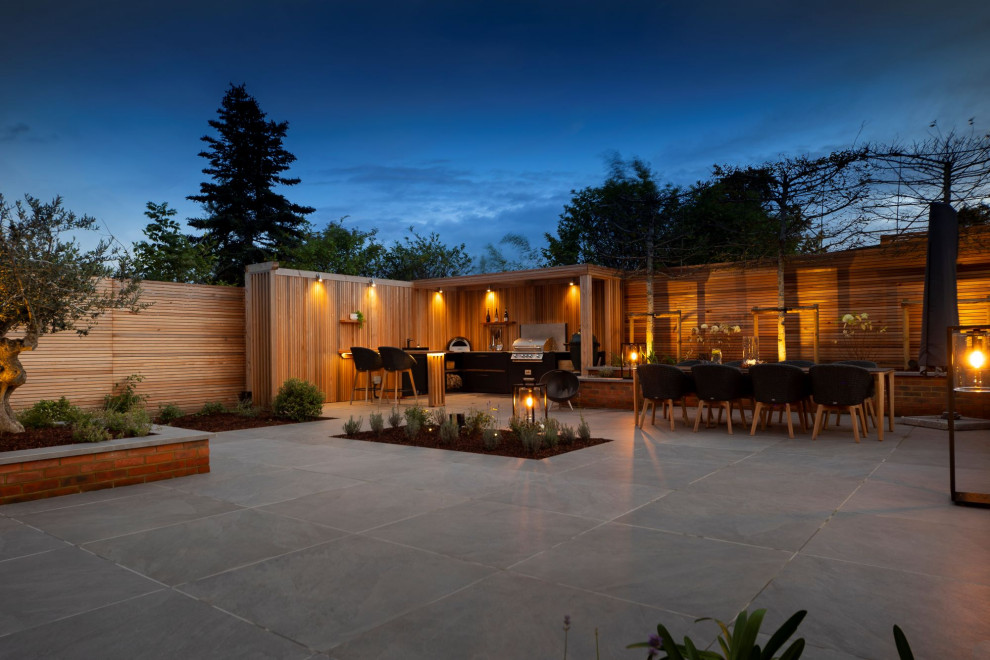 Idee per un patio o portico design di medie dimensioni e dietro casa con pavimentazioni in pietra naturale e una pergola