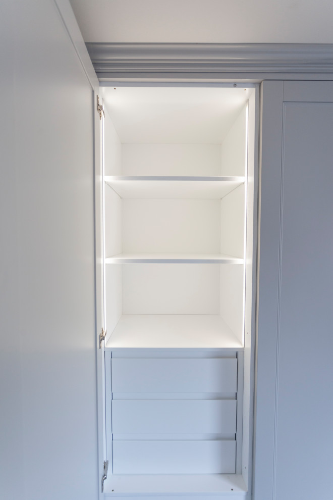 Idées déco pour une armoire encastrée moderne de taille moyenne et neutre avec un placard à porte shaker, des portes de placard grises et moquette.