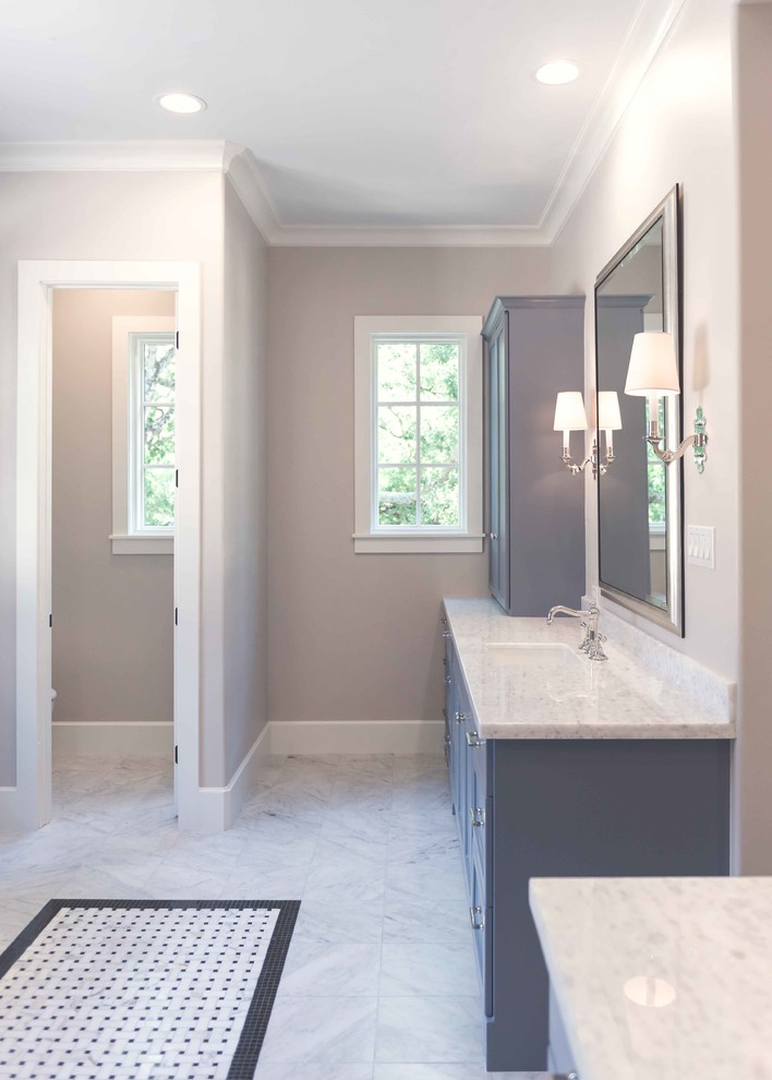 This is an example of a small traditional master bathroom in Houston with recessed-panel cabinets, blue cabinets, a freestanding tub, an alcove shower, a two-piece toilet, white tile, stone tile, grey walls, marble floors, an undermount sink and engineered quartz benchtops.