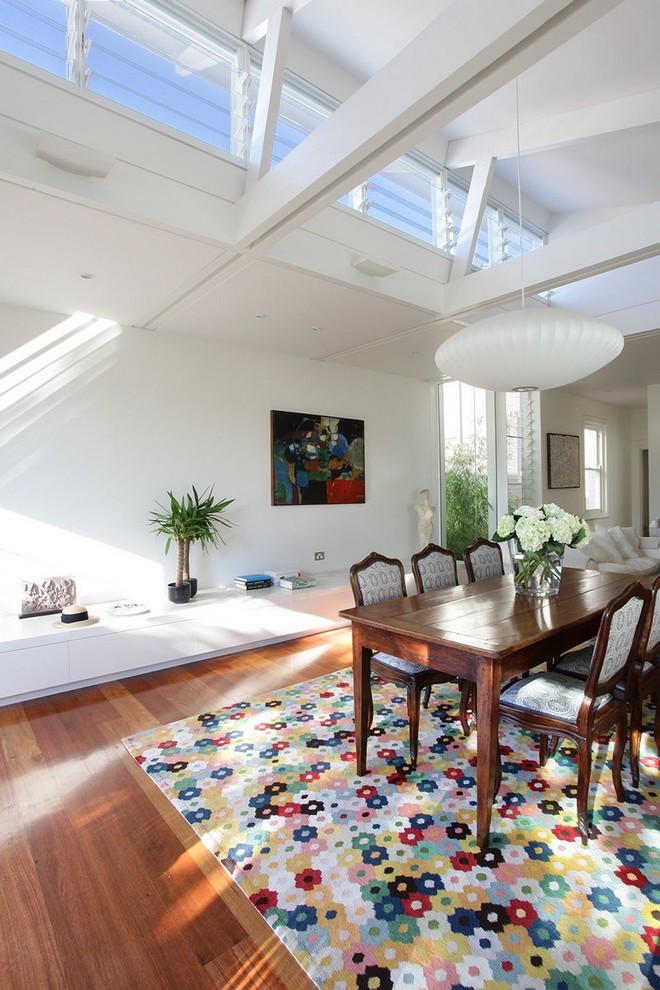Small eclectic open plan dining in Sydney with white walls, medium hardwood floors and brown floor.
