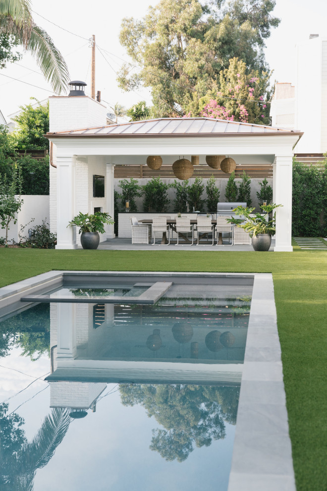 This is an example of a mid-sized beach style backyard rectangular lap pool in Los Angeles with concrete pavers.