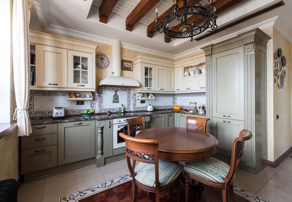 This is an example of a mid-sized traditional l-shaped eat-in kitchen in Moscow with recessed-panel cabinets, green cabinets, marble benchtops, porcelain floors, a drop-in sink, no island, multi-coloured splashback and panelled appliances.