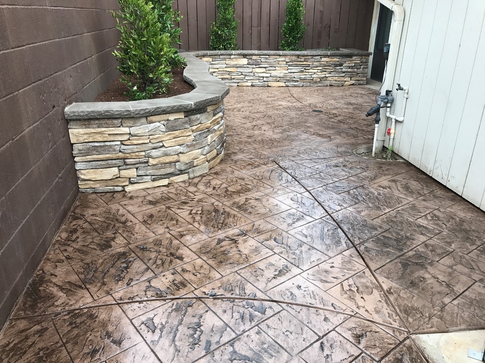 Example of a mid-sized transitional backyard stamped concrete patio design with no cover