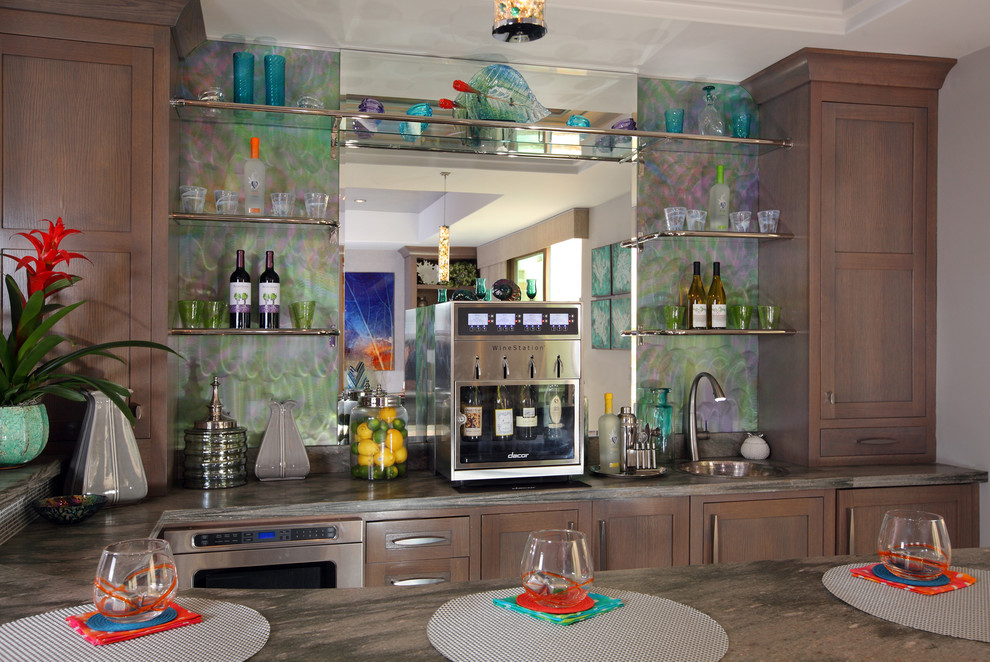This is an example of a large eclectic u-shaped seated home bar in Orange County with a drop-in sink, shaker cabinets, grey cabinets, quartzite benchtops, multi-coloured splashback, metal splashback and limestone floors.