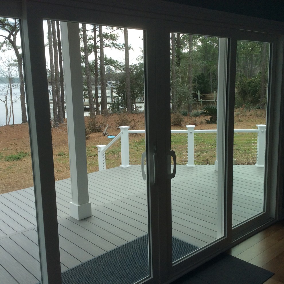 This is an example of a mid-sized beach style backyard deck in Other with an awning.