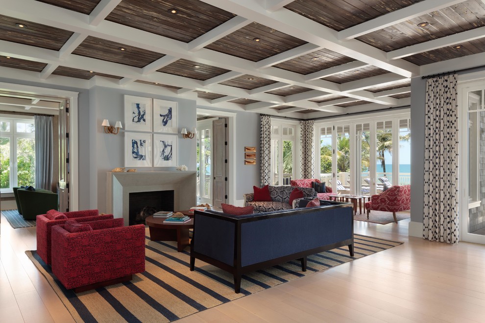 Design ideas for a large beach style formal open concept living room in Miami with blue walls, light hardwood floors, a standard fireplace and a stone fireplace surround.