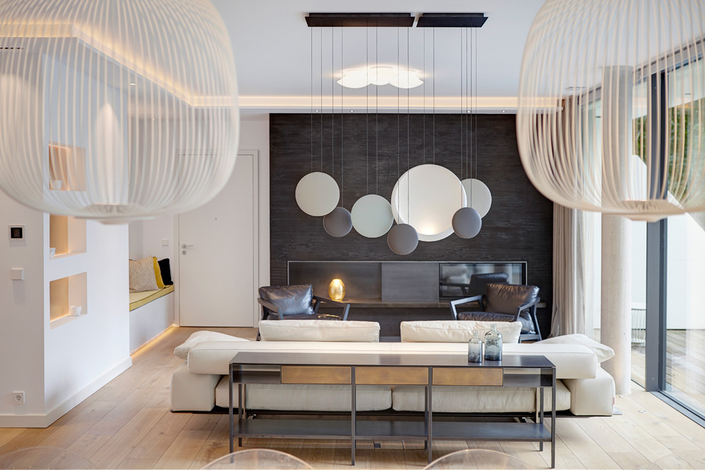 Offenes, Großes Modernes Wohnzimmer mit weißer Wandfarbe, hellem Holzboden, beigem Boden, Kamin und verstecktem TV in München