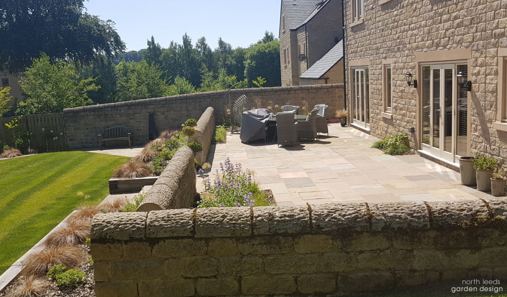 Large farmhouse back terrace with no cover.