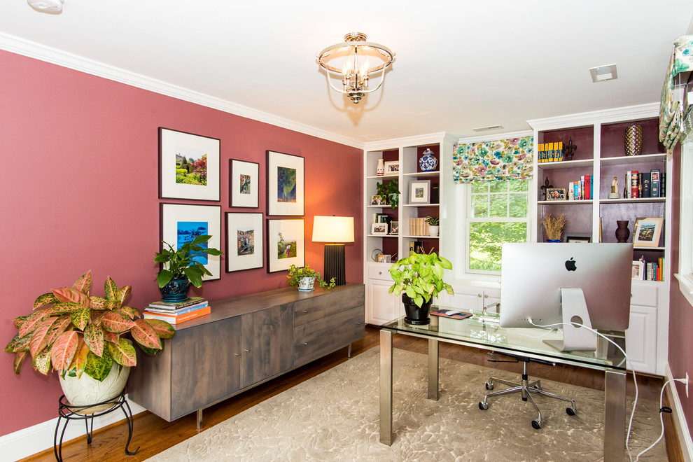 Example of a mid-sized classic freestanding desk medium tone wood floor and brown floor study room design in DC Metro with pink walls and no fireplace