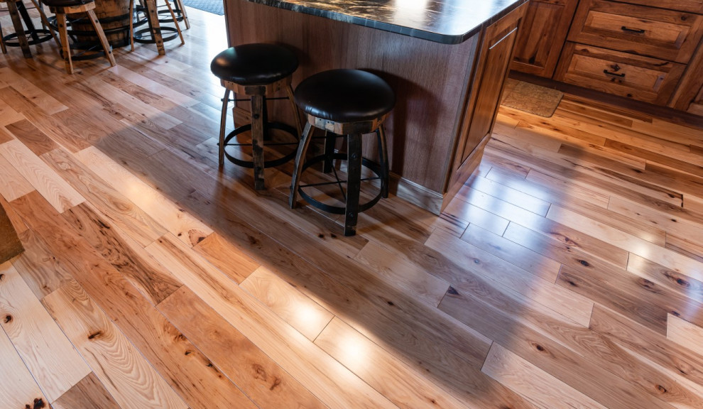 Inspiration for a rustic l-shaped medium tone wood floor kitchen remodel in Boston with an undermount sink, raised-panel cabinets, medium tone wood cabinets, granite countertops, gray backsplash, stainless steel appliances, an island and black countertops