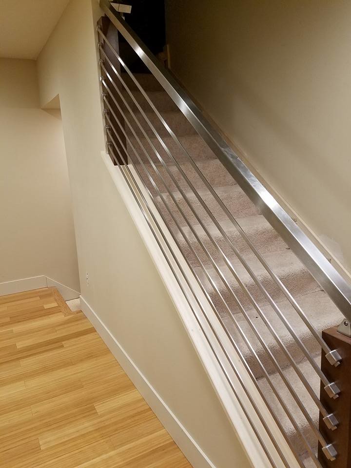 Design ideas for a contemporary carpeted straight staircase in Grand Rapids with carpet risers and metal railing.