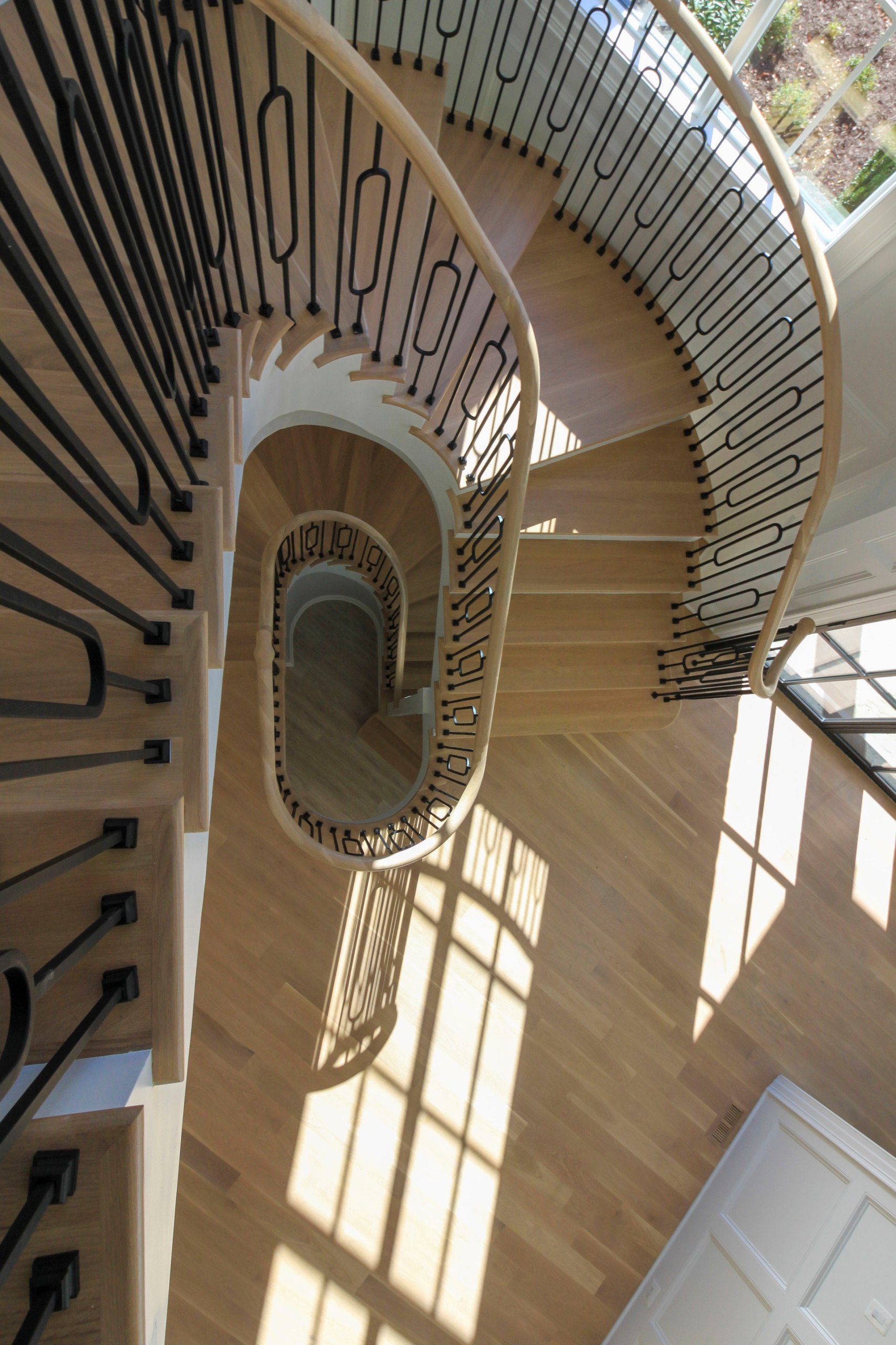 Freestanding Elliptical Staircase with Geometric Iron Balusters