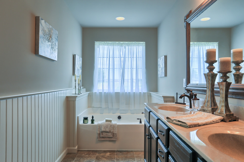 Inspiration for a large traditional master bathroom in Philadelphia with recessed-panel cabinets, dark wood cabinets, an alcove tub, beige walls and an integrated sink.
