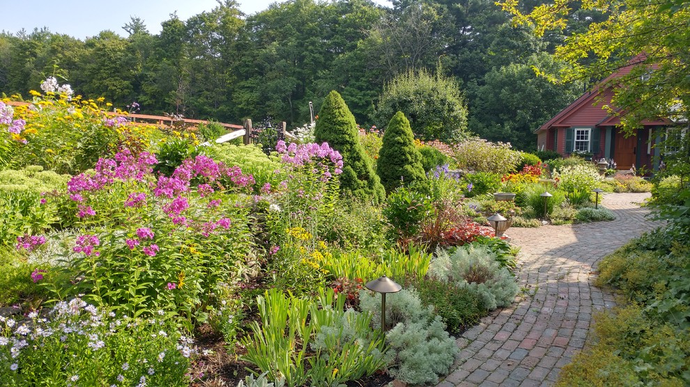 This is an example of a country partial sun garden in Boston with a garden path and brick pavers.