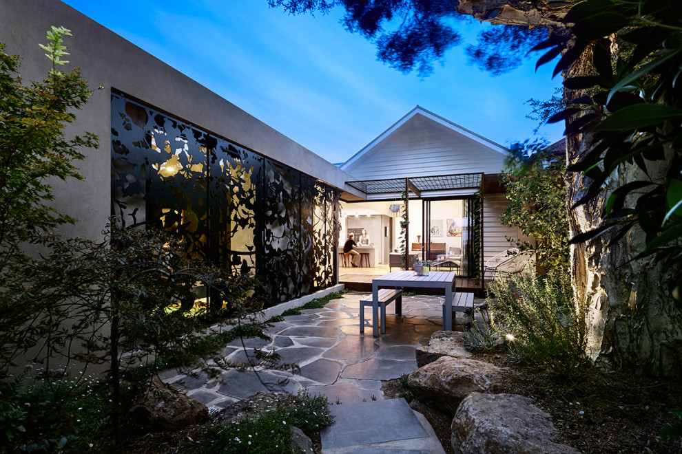 Photo of a small contemporary backyard partial sun formal garden in Melbourne with with rock feature and natural stone pavers.