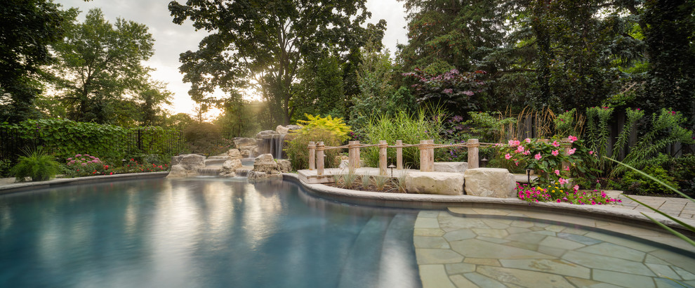 Inspiration for a mid-sized contemporary backyard custom-shaped natural pool in Toronto with a hot tub and brick pavers.