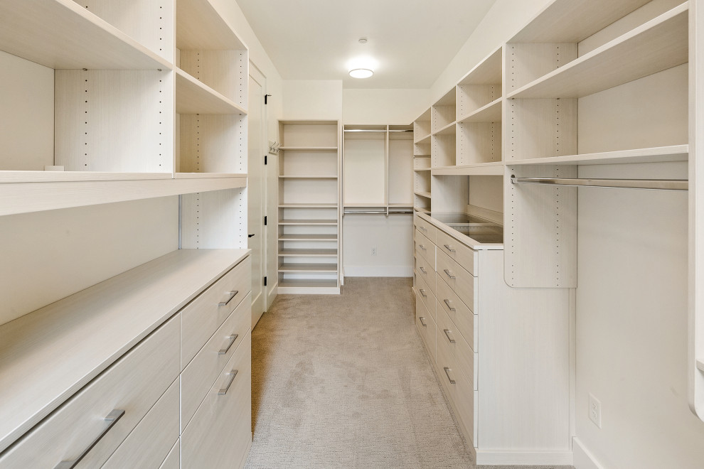Immagine di una grande cabina armadio unisex minimalista con ante lisce, ante in legno chiaro, moquette e pavimento grigio