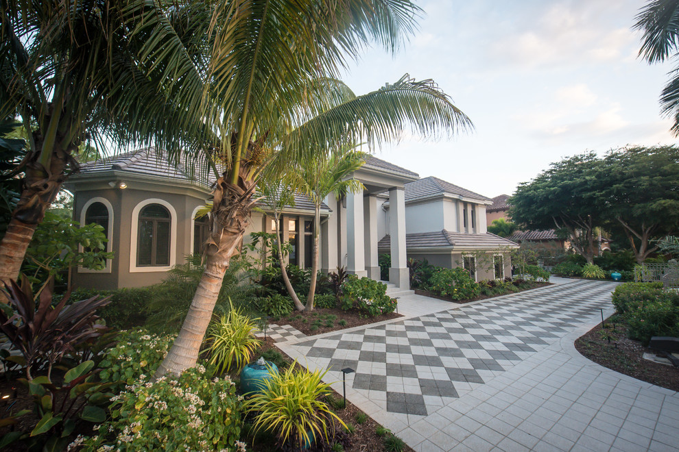 Photo of a modern front yard driveway in Tampa with concrete pavers.