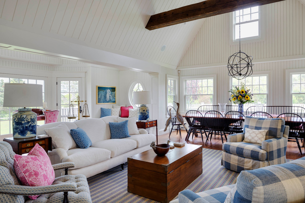 This is an example of a large country open concept living room in Boston with white walls and medium hardwood floors.