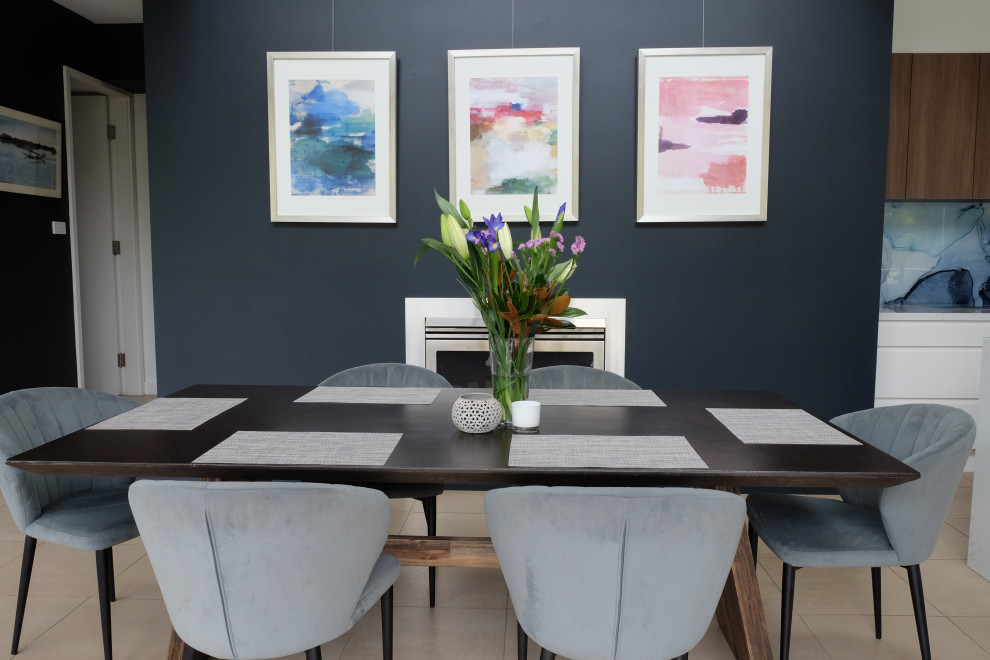 Inspiration for a mid-sized contemporary open plan dining in Sydney with blue walls, ceramic floors, a standard fireplace, a metal fireplace surround and beige floor.