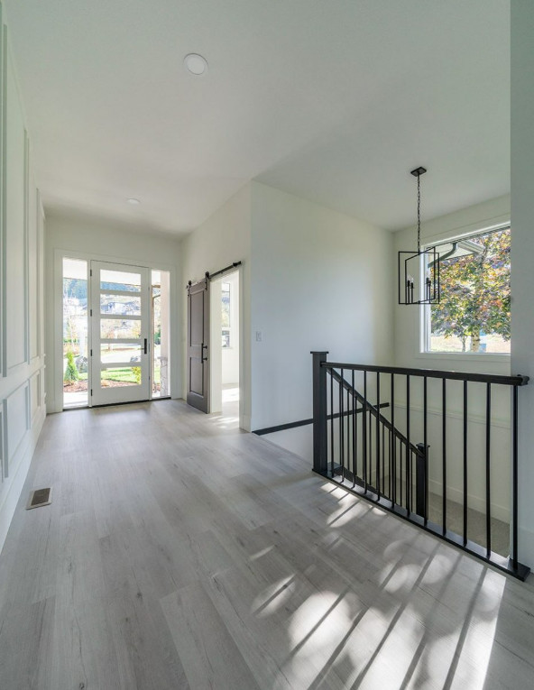 Mid-sized arts and crafts foyer in Vancouver with white walls, laminate floors, a single front door, a white front door, beige floor and panelled walls.