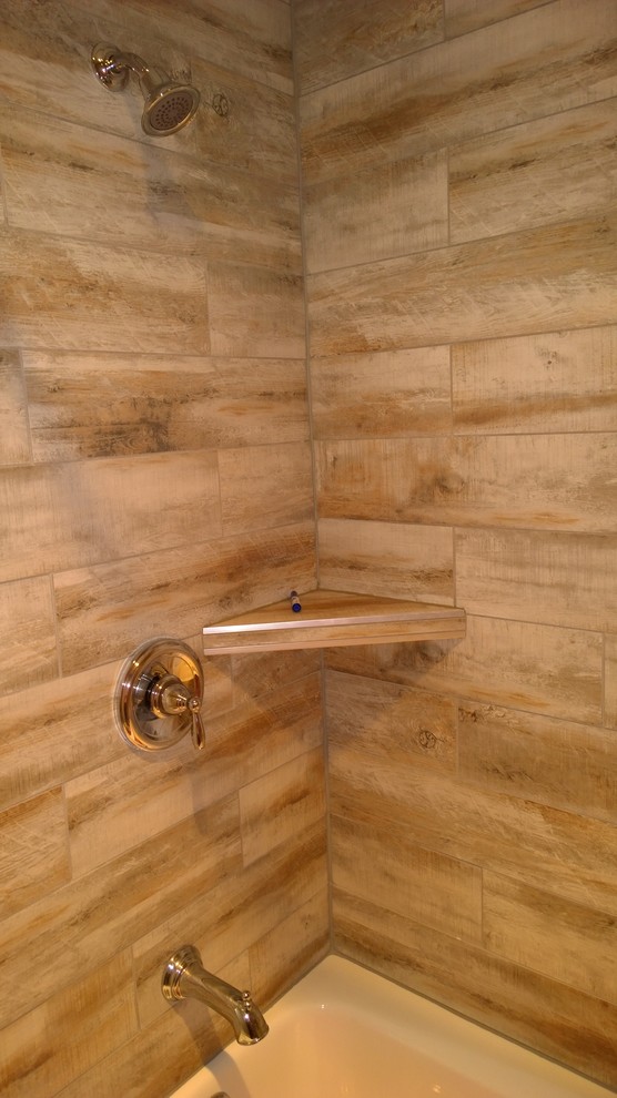 Photo of a mid-sized country kids bathroom in Other with a drop-in tub, a shower/bathtub combo, brown tile and porcelain tile.