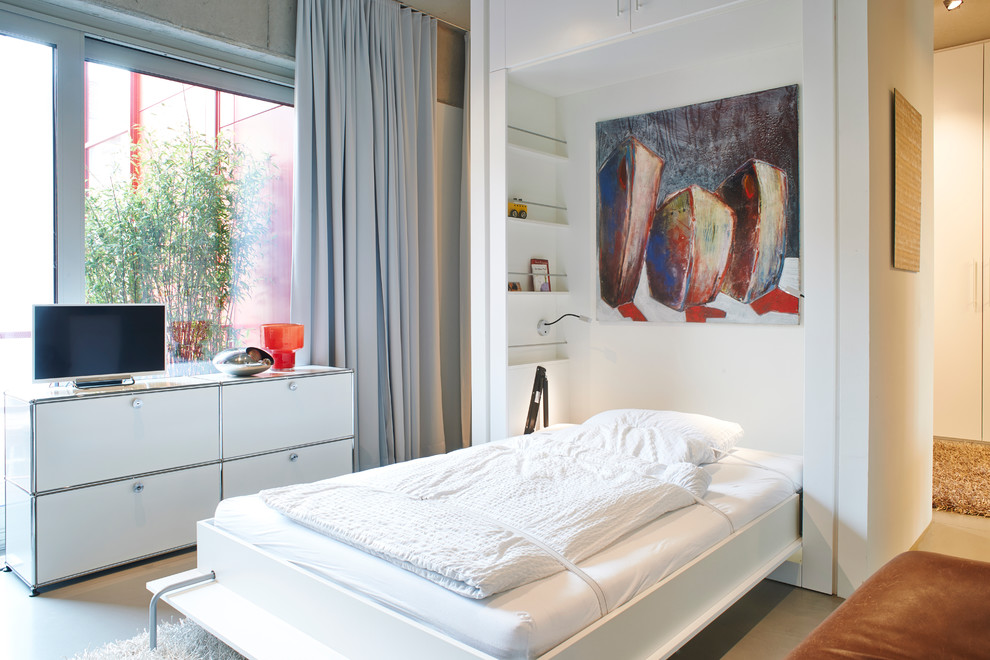 Geräumiges Industrial Schlafzimmer ohne Kamin, im Loft-Style mit grauer Wandfarbe, Betonboden und grauem Boden in Berlin